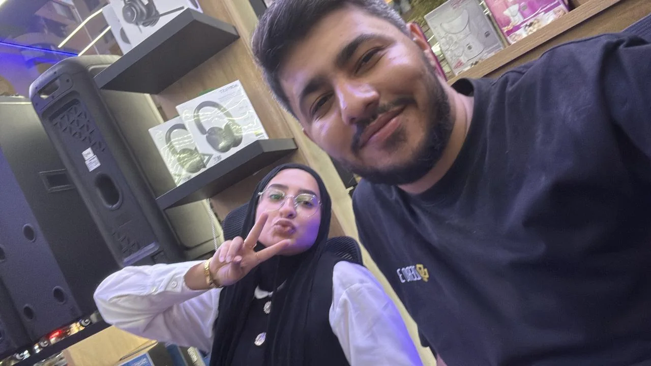 A selfie in a shop; behind me, Fatima pouts and holds up a peace sign.